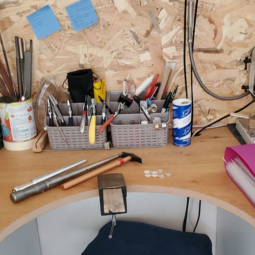 Outils de bijouterie sur l'établi de l'atelier Sealvie (enclume, marteau…) pour la fabrication d'une médaille en argent